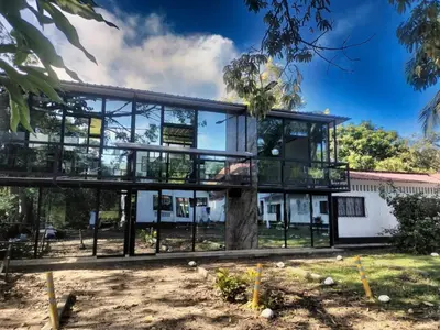 a glass house with a tree in front of it at Beautiful duplex in Honda