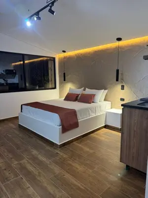 a bedroom with a large white bed with pillows at Stadium Home Shelter in Medellín