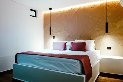 a bedroom with a bed with a stone wall at Stadium Home Shelter in Medellín