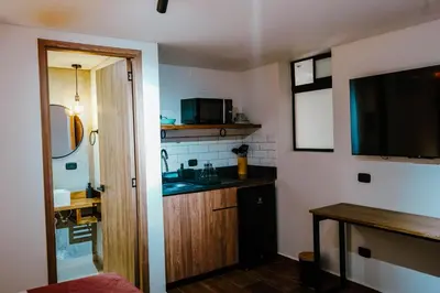 a small kitchen with a sink and a television at Stadium Home Shelter in Medellín