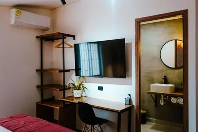 a bedroom with a desk and a mirror and a bed at Stadium Home Shelter in Medellín