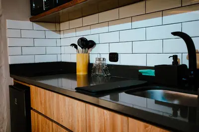 a kitchen counter with a sink and utensils at Stadium Home Shelter in Medellín