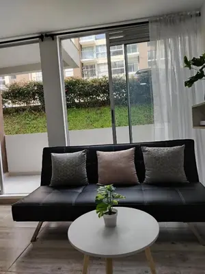 a black couch sitting in a living room with a table at Apartamento en Manizales reserva campestre in Manizales
