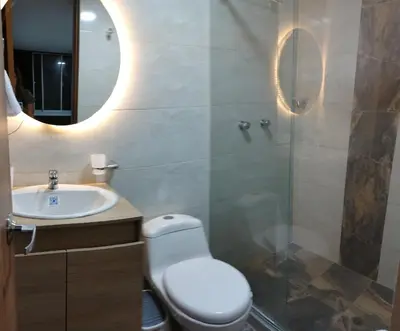 a bathroom with a toilet and a sink and a mirror at Apartamento en Manizales reserva campestre in Manizales