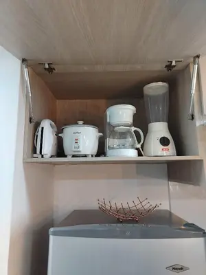 a shelf with various kitchen utensils on top of a refrigerator at Apartamento en Manizales reserva campestre in Manizales