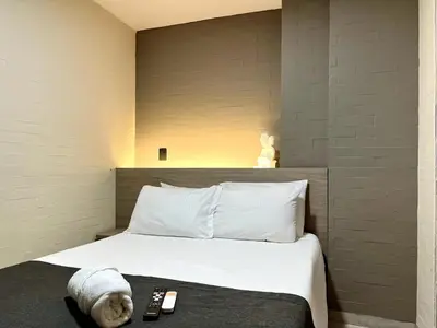 a bed with a stuffed animal laying on top of it at THE CAVE - Mancave, Pool & Arcade, by Lleras Park in Medellín