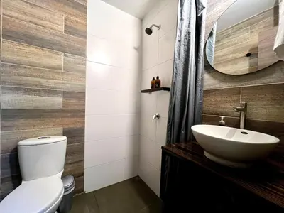 a bathroom with a white toilet and a sink at THE CAVE - Mancave, Pool & Arcade, by Lleras Park in Medellín