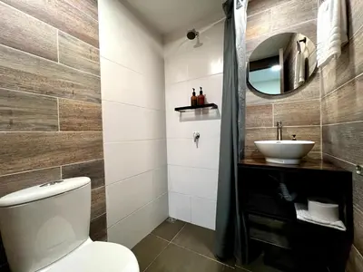 a bathroom with a white toilet and a sink at THE CAVE - Mancave, Pool & Arcade, by Lleras Park in Medellín
