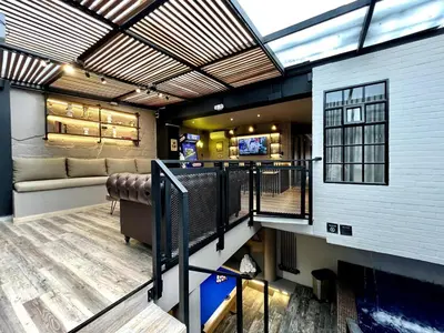 a living room with a couch and a tv in a building at THE CAVE - Mancave, Pool & Arcade, by Lleras Park in Medellín