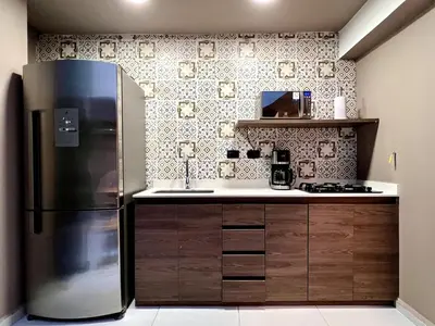 a kitchen with a refrigerator and a sink at THE CAVE - Mancave, Pool & Arcade, by Lleras Park in Medellín