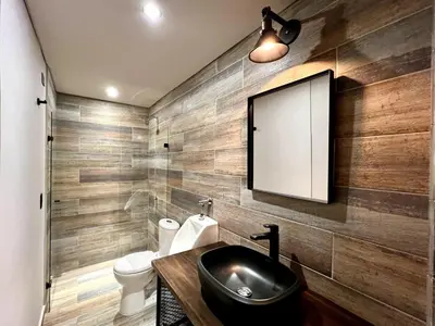 a bathroom with a sink and a toilet and a mirror at THE CAVE - Mancave, Pool & Arcade, by Lleras Park in Medellín