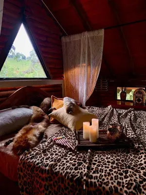 a room with a bed with two candles on it at Cabaña Caballo Dorado in Guarne