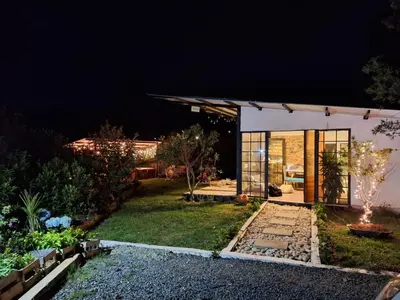 a home with a lit up yard at night at Chalet las palmas Poblado in Medellín
