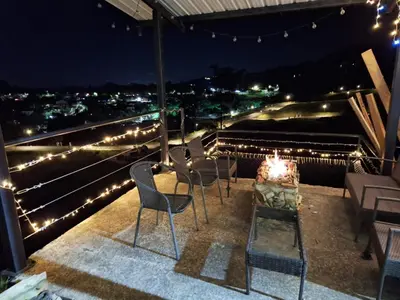 a group of chairs sitting on a balcony at night at Chalet las palmas Poblado in Medellín