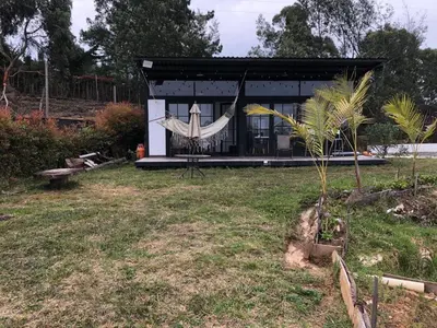 a small house with a hammock in a yard at Chalet las palmas Poblado in Medellín