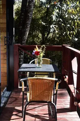 a table and chairs on a porch with a vase of flowers at Onirico Luxury in Medellín