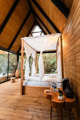 a bedroom with a canopy bed in a wooden room at Onirico Luxury in Medellín