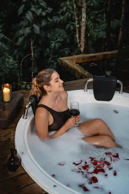 a woman sitting in a bath tub with a glass of wine at Onirico Luxury in Medellín