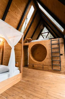a bedroom in a wooden cabin with a bed and a ladder at Onirico Luxury in Medellín