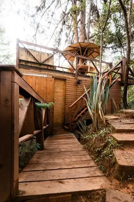 a wooden walkway leading to a building with an umbrella at Onirico Luxury in Medellín