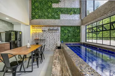 an indoor pool in a house with a table and chairs at TERRA - Heated Small Pool, BBQ & AC Lleras Park in Medellín