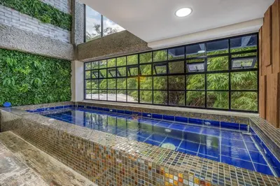 an indoor pool in a house with a large window at TERRA - Heated Small Pool, BBQ & AC Lleras Park in Medellín