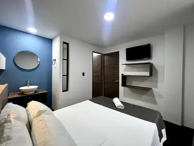 a bedroom with a white bed and a sink at ARYA - Huge Hot Tub & AC Steps from Lleras Park in Medellín