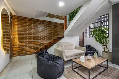 a living room with a chair and a table at ARYA - Huge Hot Tub & AC Steps from Lleras Park in Medellín