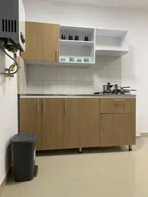 a kitchen with wooden cabinets and a trash can at Apartahotel Provenza in Medellín