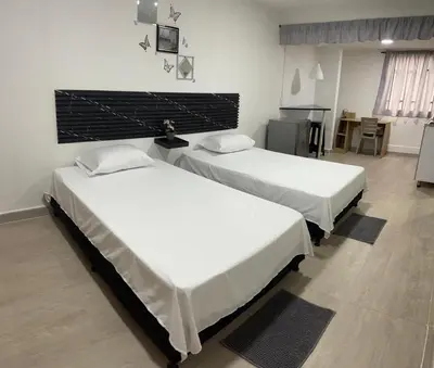 two beds sitting in a room with a room with at Apartamento amoblado en Belén in Medellín