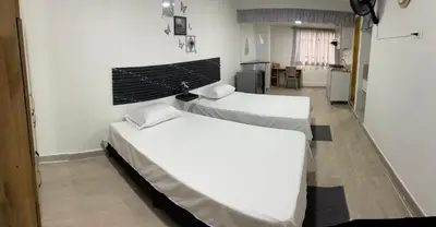 two beds in a room with white walls at Apartamento amoblado en Belén in Medellín
