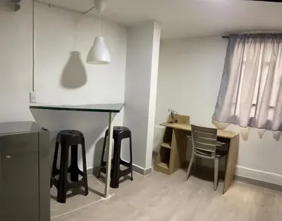 a kitchen with a table and stools in a room at Apartamento amoblado en Belén in Medellín