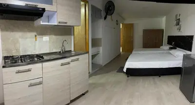 a bedroom with a bed and a kitchen with a sink at Apartamento amoblado en Belén in Medellín