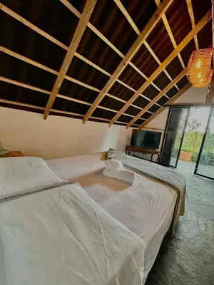 a bedroom with two white beds and a ceiling at Encanto Verde cabaña sencilla in Marinilla