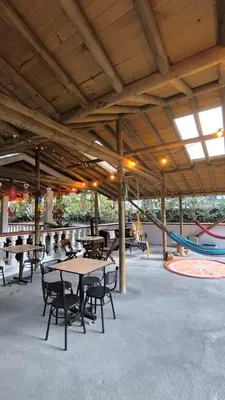 an outdoor patio with tables and chairs and a slide at Hostal Servus Pizzeria café in San Carlos