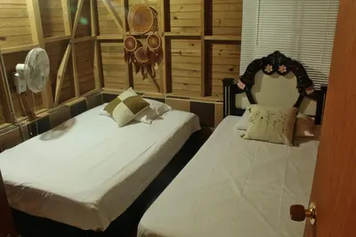 two beds in a room with two beds sidx sidx sidx at Hostal Servus Pizzeria café in San Carlos