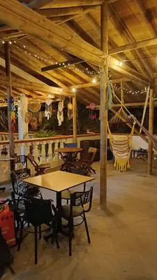 a room with tables and chairs in a building at Hostal Servus Pizzeria café in San Carlos