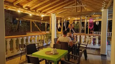 a man and woman sitting at a table in a restaurant at Hostal Servus Pizzeria café in San Carlos