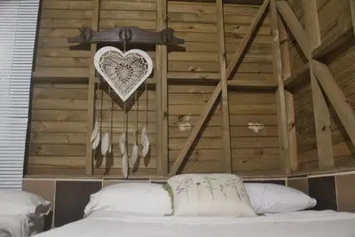 a bedroom with a heart hanging above a bed at Hostal Servus Pizzeria café in San Carlos