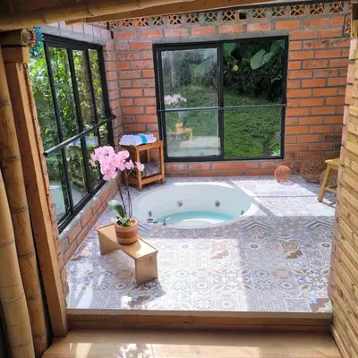 a jacuzzi tub in a room with windows at Glamping Manzara in Manizales