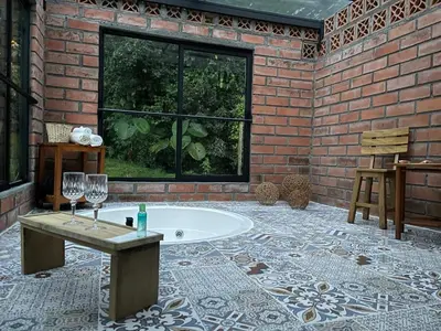 a bathroom with a tub and a brick wall at Glamping Manzara in Manizales