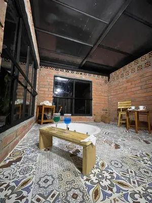 a bath tub in a room with a brick wall at Glamping Manzara in Manizales