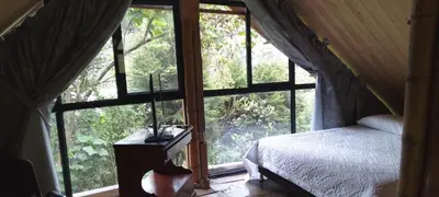 a bedroom with a bed and a large window at Glamping Manzara in Manizales