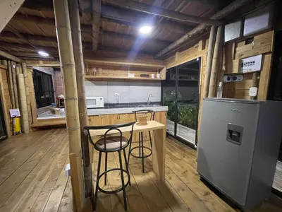 a kitchen with a small table and a refrigerator at Glamping Manzara in Manizales