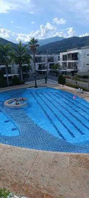 a large blue swimming pool in front of a building at Apartasol Santafe de Antioquia in Santa Fe de Antioquia