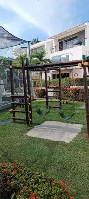 a park with two swings in the grass at Apartasol Santafe de Antioquia in Santa Fe de Antioquia