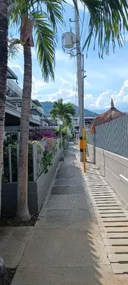 a sidewalk with palm trees next to a building at Apartasol Santafe de Antioquia in Santa Fe de Antioquia