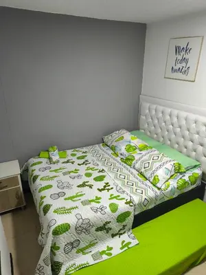 a bedroom with a bed with a green comforter at Apartasol Santafe de Antioquia in Santa Fe de Antioquia