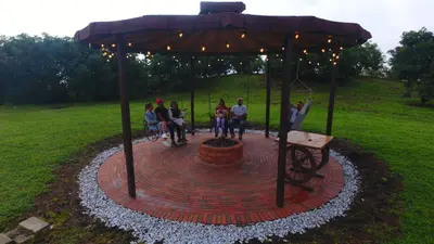 a group of people sitting under an umbrella at Valle Sereno, Hospedaje rural cerca del Salto del Buey in Abejorral