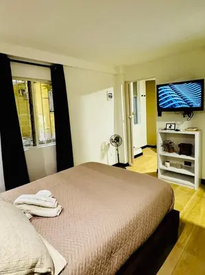 a bedroom with a bed and a flat screen tv at Apartaestudio Medellin - Santa Lucia in Medellín